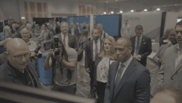 A crowd gathers around HUD Secretary Scott Turner as he visits the Aareas Interactive booth at the 2025 MHI Congress & Expo, viewing the Home Configurator demonstration.
